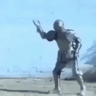 A Man In A Knight 'S Armor Is Standing On A Dirt Road . GIF