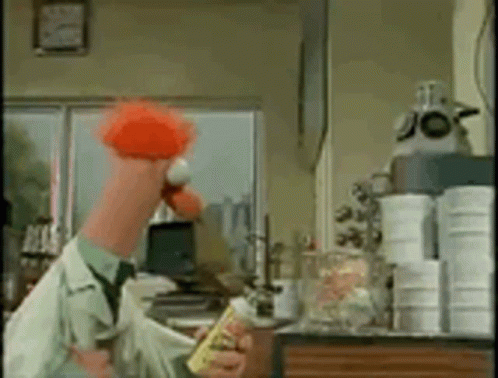 A Man In A Lab Coat Is Holding A Yellow Bottle And A Red Flower . GIF
