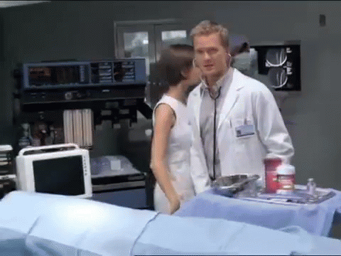 A Man In A Lab Coat Is Listening To A Woman With A Stethoscope GIF