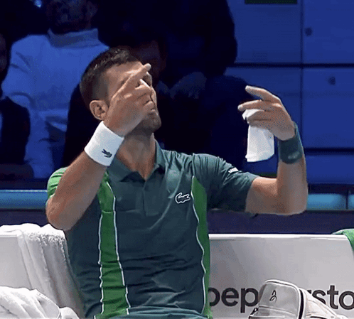 A Man In A Lacoste Shirt Wipes His Nose GIF