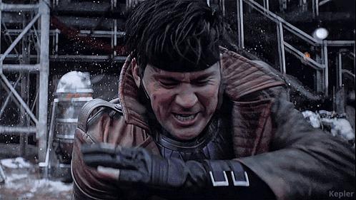 A Man In A Leather Jacket And Gloves Is Standing In The Snow With Kepler In The Corner GIF