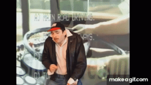 A Man In A Leather Jacket Is Dancing In Front Of A Screen That Says ' At Least Road Driving ' On It GIF