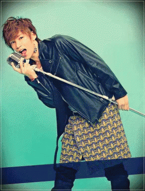 A Man In A Leather Jacket Is Holding A Microphone GIF