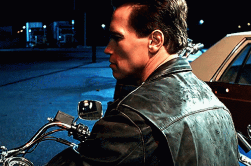 A Man In A Leather Jacket Is Riding A Motorcycle GIF