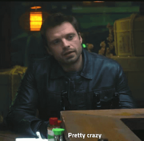 A Man In A Leather Jacket Is Sitting At A Table With Bottles And Says Pretty Crazy GIF