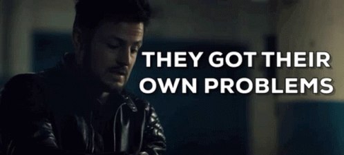 Man In Leather Jacket Sitting In Front Of Sign Saying They Got Their Own Problems GIF