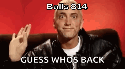 A Man In A Leather Jacket Is Sitting On A Couch And Making An Ok Sign . GIF
