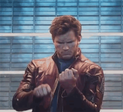 A Man In A Leather Jacket Is Standing In Front Of A Brick Wall And Making A Funny Face . GIF