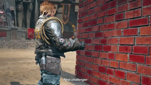 A Man In A Leather Jacket Is Standing Next To A Brick Wall And Says New Challenger GIF
