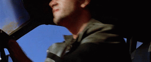 A Man In A Leather Jacket Looks Out Of The Window Of A Car GIF