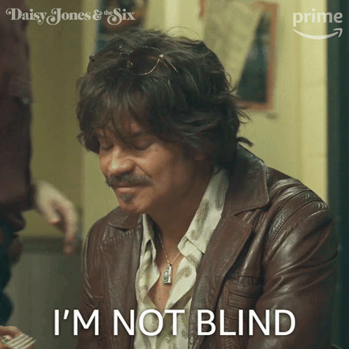 A Man In A Leather Jacket Says " I 'M Not Blind " In Front Of A Picture Of Daisy Jones And The Six GIF