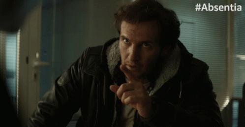 A Man In A Leather Jacket Says Thank You With His Finger On His Lips GIF