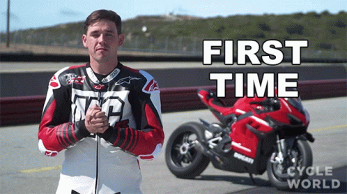 A Man In A Leather Jacket Stands In Front Of A Red Motorcycle That Says First Time GIF