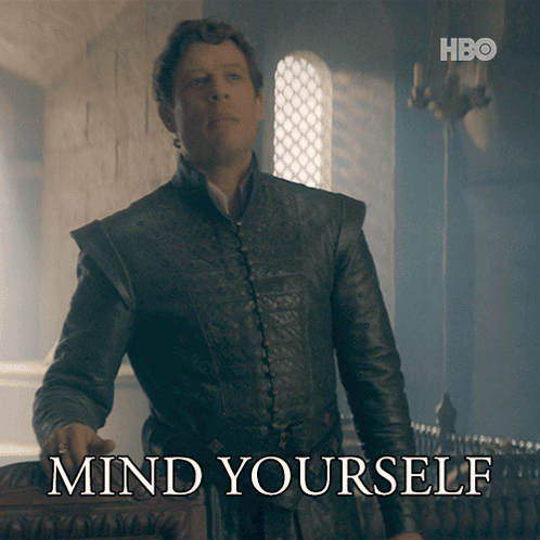 A Man In A Leather Jacket Stands In Front Of A Sign That Says " Mind Yourself " GIF