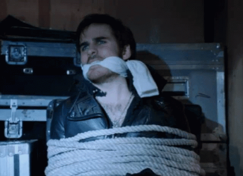 A Man In A Leather Jacket Tied Up With Rope GIF