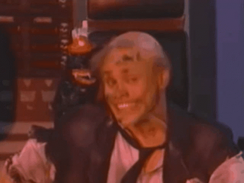 A Man In A Leather Vest And Tie Is Laughing GIF