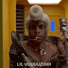 A Man In A Leopard Print Coat Is Holding A Cane In His Hand And Talking On A Cell Phone . GIF