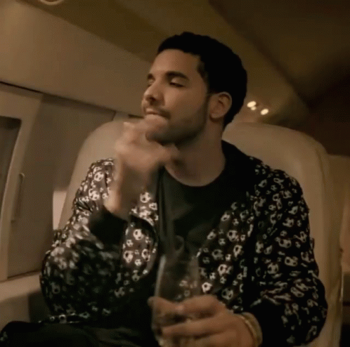 A Man In A Leopard Print Jacket Holds A Glass In His Hand GIF