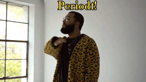 A Man In A Leopard Print Jacket Stands In Front Of A Window With The Word Periodt Written Above Him GIF