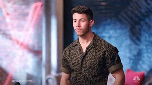 A Man In A Leopard Print Shirt Is Standing In Front Of A Nbc Logo GIF