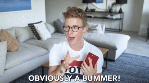 A Man In A Living Room Holding A Cell Phone And Says Obviously A Bummer GIF