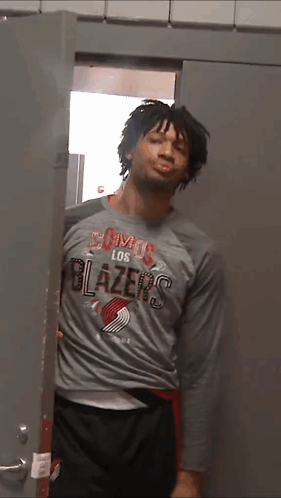 a man in a los blazers shirt is standing in a doorway