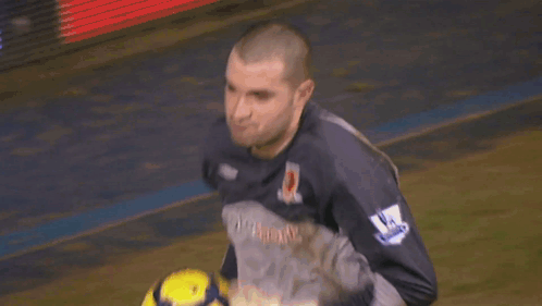 A Man In A Lottosport Jersey Holds A Soccer Ball In His Hands GIF