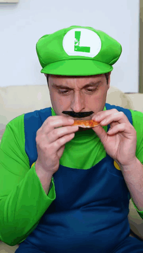 A Man In A Luigi Costume Eating A Piece Of Pizza GIF