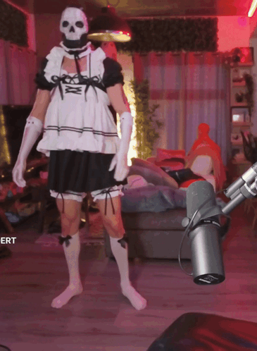A Man In A Maid Costume Is Standing In Front Of A Microphone With The Word Ert On The Bottom GIF