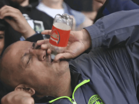 A Man In A Manchester Jacket Drinks From A Glass GIF