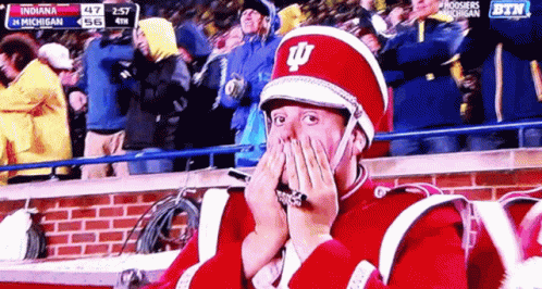 A Man In A Marching Band Uniform Covering His Face With His Hands GIF