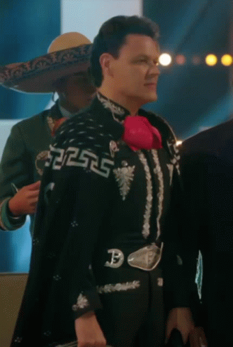 a man in a mariachi outfit has a belt with the letter p on it