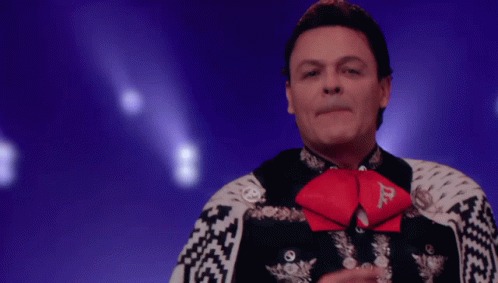 a man in a mariachi outfit has a red bow tie with the letter d on it