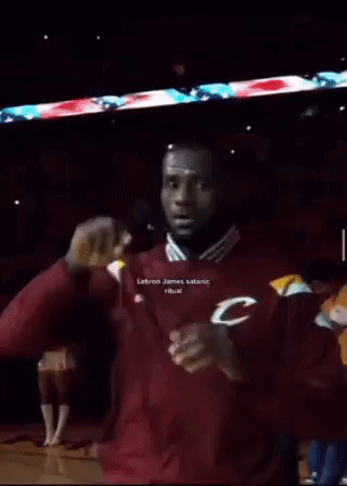A Man In A Maroon Adidas Jacket Stands In Front Of A Sign That Says 666 GIF