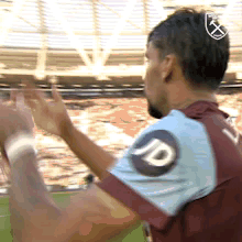 A Man In A Maroon And Blue Shirt With The Letter D On It GIF