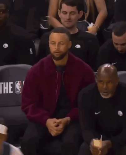 A Man In A Maroon Jacket Sits In A Nba Stadium Seat GIF