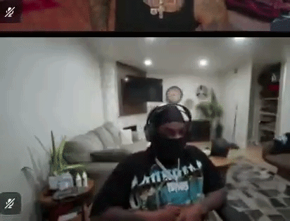 A Man In A Mask And Headphones Is Sitting In A Living Room . GIF