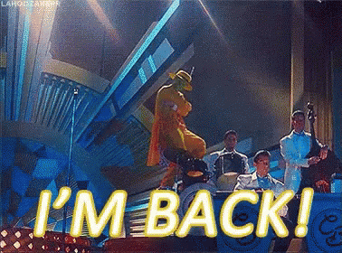 A Man In A Mask Is Dancing On A Stage With A Band And The Words I 'M Back GIF