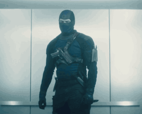 A Man In A Mask Is Holding A Knife GIF