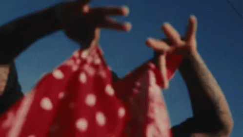 A Man In A Mask Is Holding A Woman In A Red And White Dress . GIF