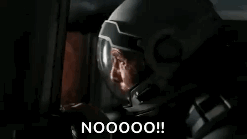 a man in a mask is looking at a computer screen and saying nooooo !