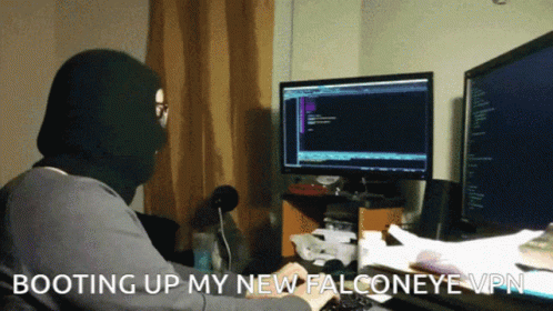 A Man In A Mask Is Typing On A Keyboard With The Words Booting Up My New Falconeye Vpn GIF