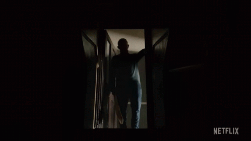 A Man In A Mask Is Walking Down The Stairs With A Netflix Logo In The Corner GIF