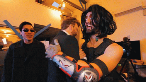 A Man In A Matrix Costume Is Being Hugged By Another Man GIF