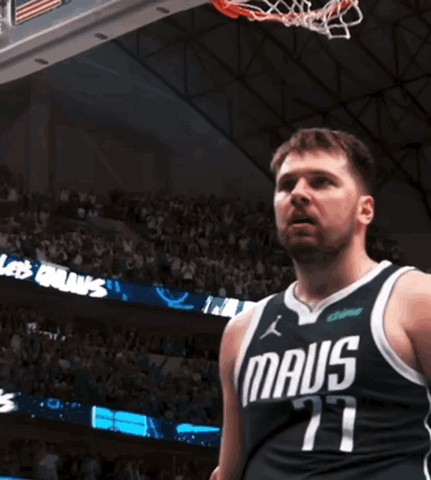 A Man In A Maus Jersey Stands In Front Of A Basketball Hoop GIF