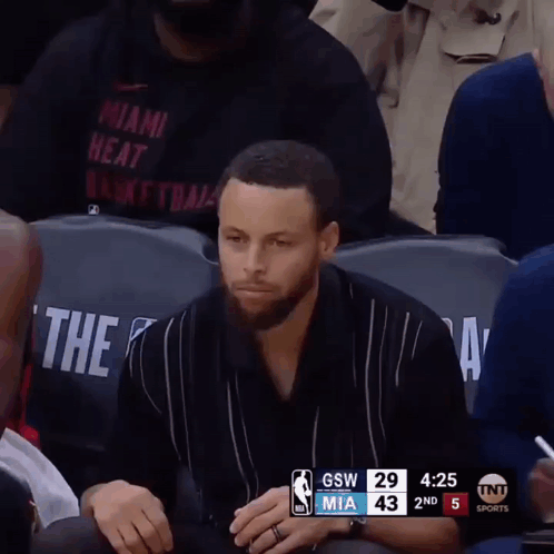 A Man In A Miami Heat Shirt Sits In The Stands GIF