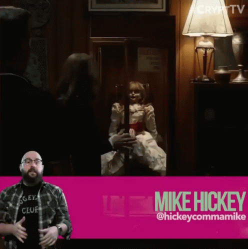 A Man In A Mickey Club Shirt Stands In Front Of A Pink Sign That Says Mike Hickey GIF