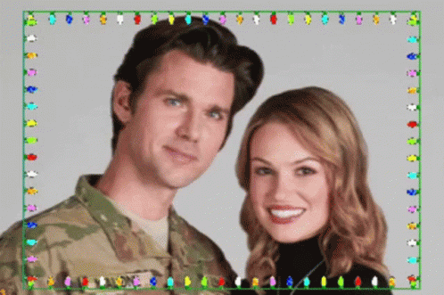 A Man In A Military Uniform And A Woman In A Black Turtleneck Pose For A Picture GIF