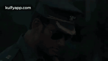 A Man In A Military Uniform And Sunglasses Is Wearing A Hat . GIF