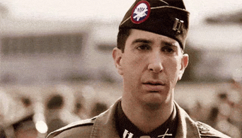 A Man In A Military Uniform Has A Patch On His Hat That Says Ii . GIF